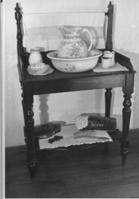 Dark timber wash stand with turned legs.