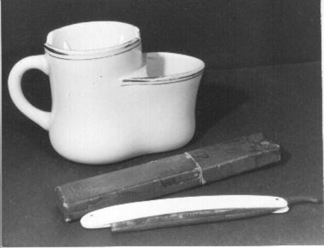 White jug shaped with basin at top with hole in middle. 