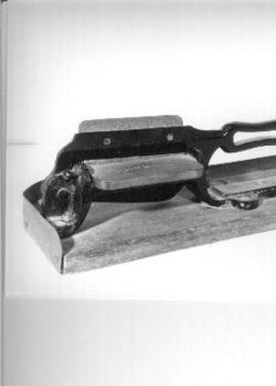 Black metal guillotine type slicer for cutting tobacco from plug.