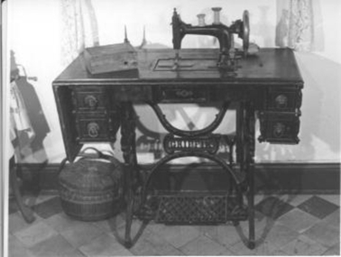 Large hand and foot operated transverse shuttle sewing machine with ornate foot treadle. 