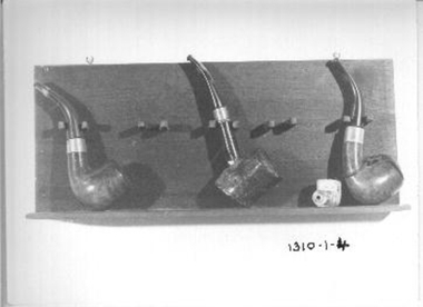 Wooden pipe rack with five wooden supports. 