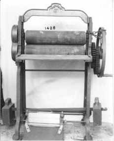 Iron stand on which is fitted two wooden rollers
