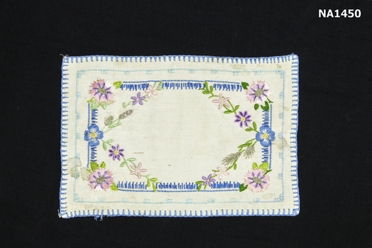  White cotton rectangular doyley edged in blue blanket stitch. 