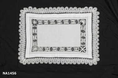 White linen rectangular tray cloth. Hand hem stitching around edges and deep border of drawn thread work. 