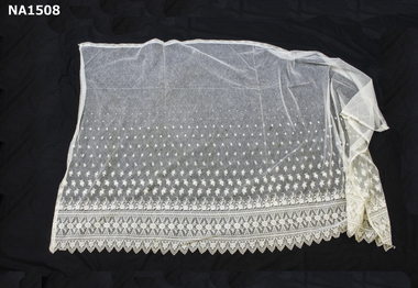 Cream mesh curtain with scalloped edges.