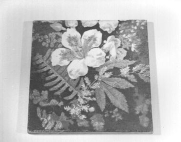 Square glazed tile with brown background with lighter brown leaves and fern leaf
