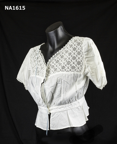 White cotton bust bodice with deep edging of crochet lace at neck and on short sleeves.