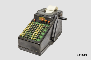 Hand operated comptometer or adding machine with side handle.
