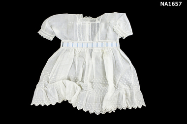 White lawn infant dress with small spot.