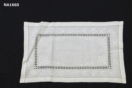 White tray cloth with white embroidery and draw thread inner border.