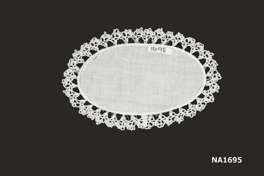  Oval white cotton doyley with crochet edging.