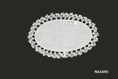  Oval white cotton doyley with crochet edging.