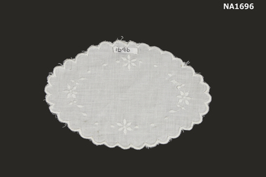 Oval white cotton doyley with white embroidery. 