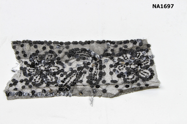 Piece of black lace oversewn with black sequins.