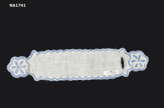 White cotton serviette ring embroidered in blue in flower pattern and blue scalloped edging.