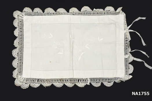 White cotton pillow case with deep crochet edging with white embroidery in centre. 
