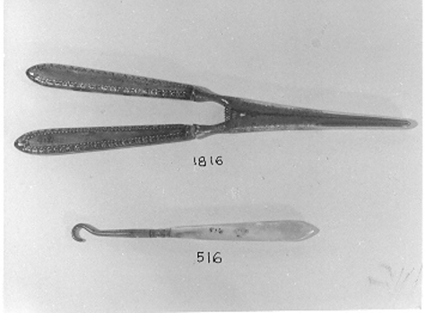 Metal glove stretcher with two prongs and decorated handles.