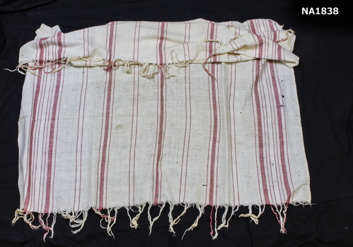 White cotton rug with red stripes and fringing in red and white.