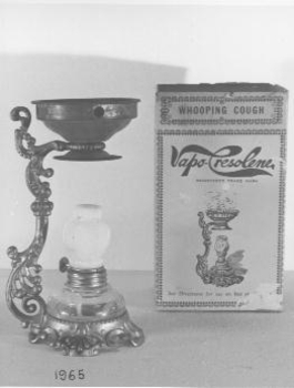 Ornate gold painted stand with glass bottle burner.