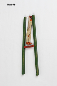 Wooden clown tied to two green poles