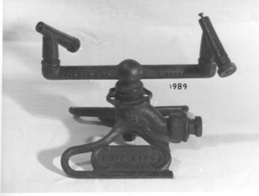 Lawn sprinkler with two splayed legs acting as a stand. 