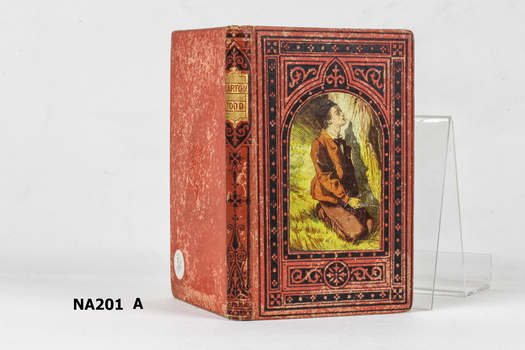 Red hard cover book with picture of kneeling boy on front. 