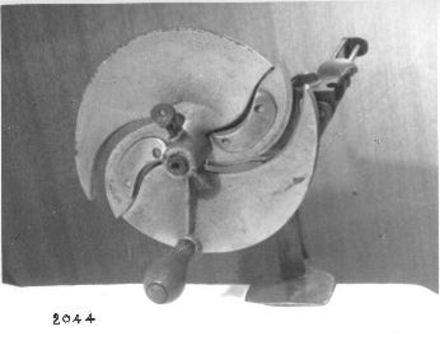 Metal food cutter with rotary blade and handle. 