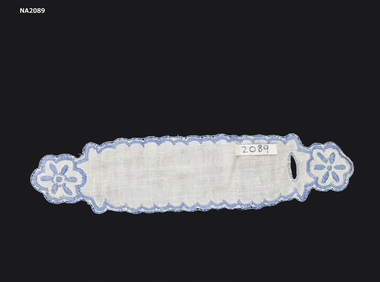 White cotton serviette ring embroidered in blue with blue flower pattern at each end.