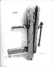 Two large pieces of wood with a wide holed metal piece at one end.