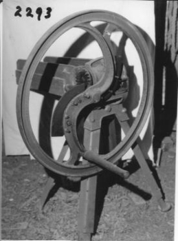  Large red painted wheel with two cutting blades.