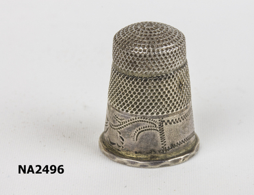 Small silver thimble with design etched around the top.