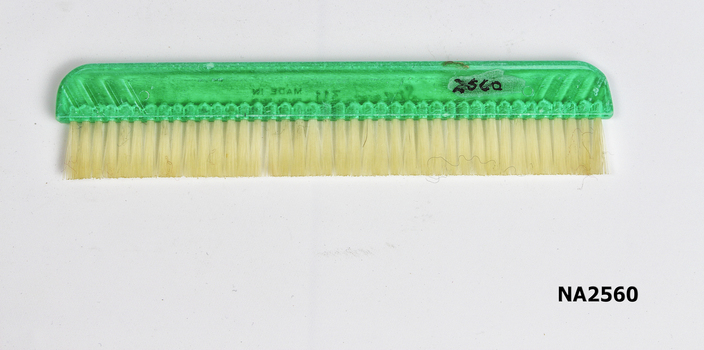 Small travelling clothes brush.