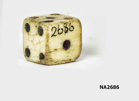 Large ivory or bone dice with recessed black dots.