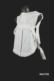 Childs white lawn pinafore with Broderie Anglais all around edge, two ties at waist with Broderie on each end.