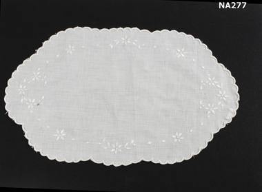 White embroidered oval doyley. 