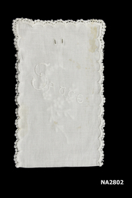 White cotton oblong cover, crochet around white floral embroidery on one side and sauce embroidered on other side. Two slits, probably tied with a ribbon.