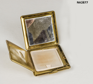 Small square gilt finished pressed metal compact.