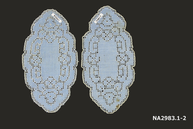 A pair of blue linen mats with white embroidery thread on drawn thread work with scalloped edge.