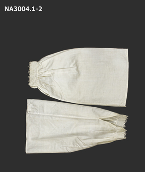 A pair of lawn sleeve covers in cream. Sleeves gathered to cuffs with hemmed slit for plackets.