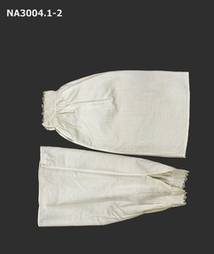 A pair of lawn sleeve covers in cream. Sleeves gathered to cuffs with hemmed slit for plackets.