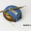 Round wooden block with sample of material to demonstrate how to use the darner and needles.