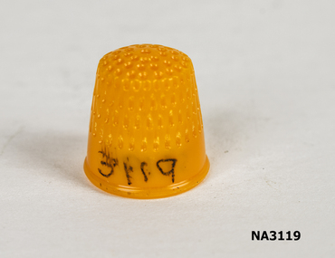 Small yellow plastic thimble for finger when sewing.