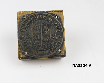 Square wooden block on which round metal plate nailed; 