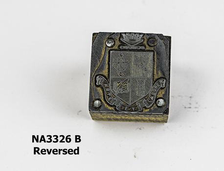 Small wooden block with metal Coat of Arms nailed to top