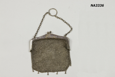 Small silver metal purse with silver chain handle. 