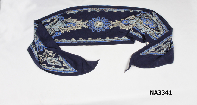 Rectangular scarf with navy blue background and printed lace design in two blues and white.