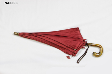 ption  Red cotton umbrella with plastic handle and paint in a marble pattern.
