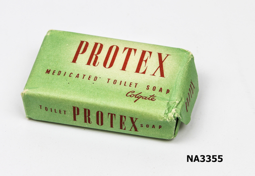Cake of toilet soap wrapped in pale green paper with red printing