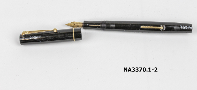 A black bakelite pen with gold ink lever, pocket grimp and circle trim around lid.