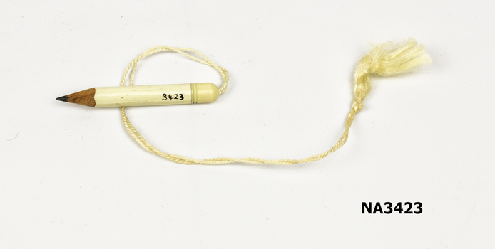 A small white dance card pencil with cap holding string,